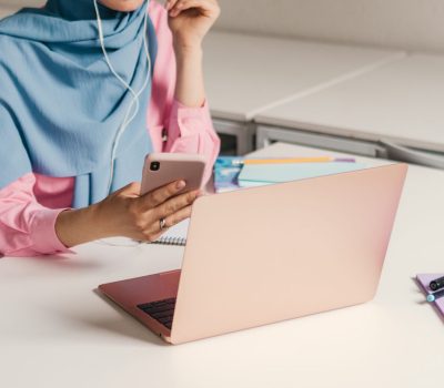 young pretty modern muslim woman in hijab working on laptop in office room, education online, remote work freelancer, using smatphone thinking